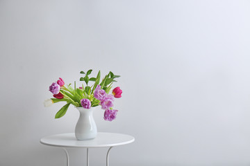 Bouquet of beautiful flowers on table against light background