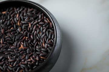 Schwarzer Reis roh in Porzellan Schale auf Marmor Hintergrund 