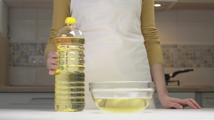 Woman Pours Oil Into A Transparent Bowl