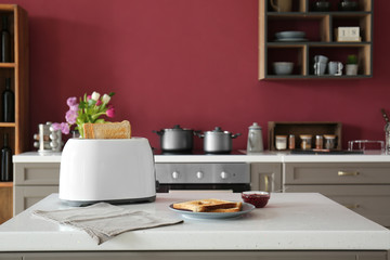 Toaster with bread and jam on table in kitchen