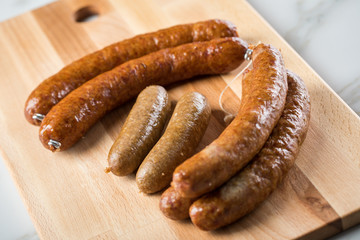 Regionale norddeutsche Grünkohl Kohlwurst Variation aus Bremer, Oldenburger und Ammerländer Pinkel auf  Holzbrett auf Marmor Tisch