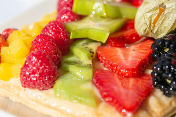 close-up view of a tart with stripes of fruits aligned