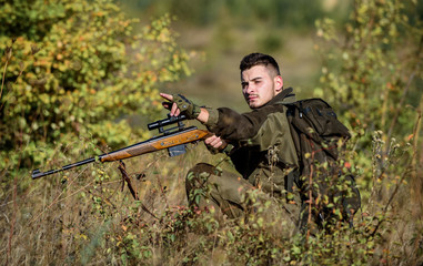 Hunter hold rifle. Man wear camouflage clothes nature background. Hunting permit. Bearded serious...