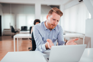 Annoyed business man looking at laptop screen.