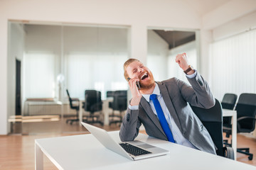 Excited businessman celebrating business success.
