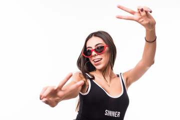 Portrait of a smiling happy woman showing victory sign and looking at camera isolated on white background