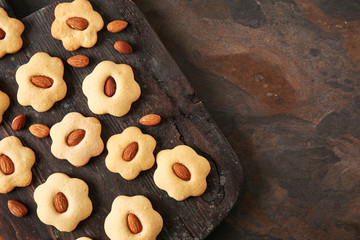 Naklejka premium Wooden board with tasty cookies on dark table