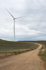 Fototapeta na wymiar Road leading to a Wind turbine