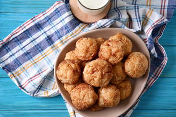 Plate with tasty cookies and glass of milk on wooden table