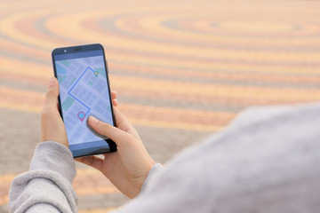 Woman using mobile phone for navigation outdoors
