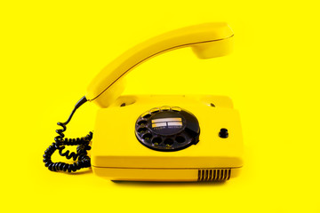 Retro vintage phone handset plastic yellow disko background old style 90 telephone answer call...