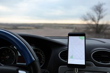 Mobile phone displaying map on screen for car driver