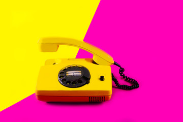 Retro vintage phone handset yellow pink red purple plastic orange disko background old style shadow...