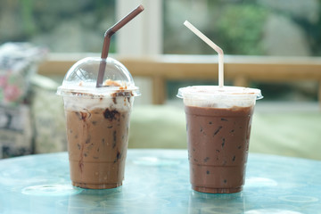 Two plastic take away cup of iced coffee mocha and iced chocolate