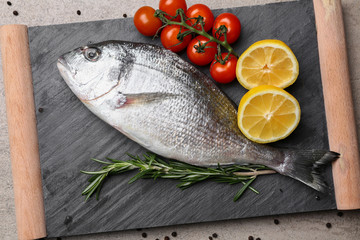 Fresh fish, tomato and lemon on board