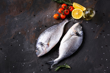 Fresh fish, tomato and lemon on table