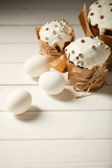 Fototapeta na wymiar traditional easter cakes with chicken eggs on white wooden surface