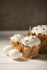 selective focus of traditional easter cakes with chicken eggs on white wooden surface