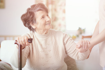 Smiling senior hospice patient with walking cane - obrazy, fototapety, plakaty