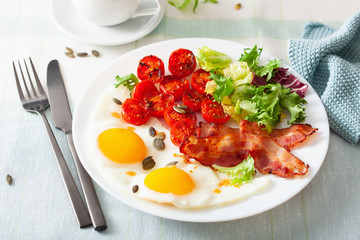 healthy keto diet breakfast: egg, tomatoes, salad leaves and bacon