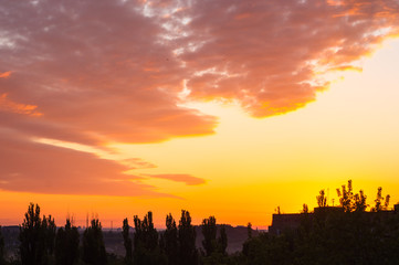 Landscape with dramatic light - beautiful golden sunset with saturated sky and clouds.