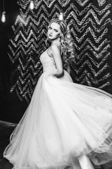 Close up black and white portrait of elegant fashionable beautiful bride with curly hairstyle indoors. Wedding, glamour, black and white photo concept