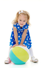 Little girl is playing with a ball