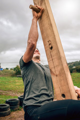 Male participant in a obstacle course doing pegboard obstacle