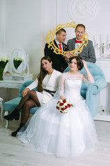 Naklejka premium wedding photoshoot in the Studio. the bride and groom with friends having fun