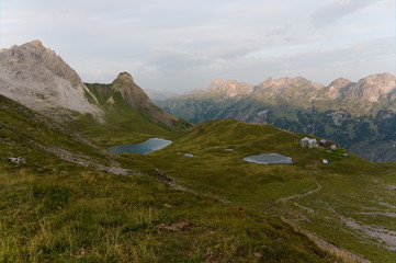 Obraz premium Mountain Hut. Solitary Cabin with a mountain range in the background
