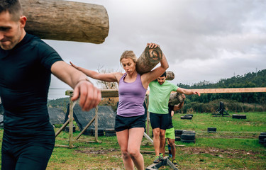 Participants in an obstacle course carrying trunks outdoors