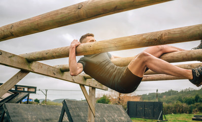 Male participant in a obstacle course doing weaver obstacle