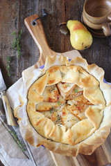 Pear tart galette with caramelized onions and Parmesan cheese, thyme garnish