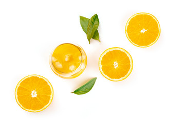 A glass of fresh orange juice with orange halves and green leaves, shot from above on a white background with a place for text