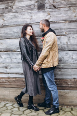 Tender romantic cheerful happy couple walking outdoors hugging and kissing each other outdoors in park. Relationships, love, hipster couple concept