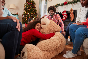 Obraz premium Children Playing With Giant Teddy Bear As Multi-Generation Family Open Gifts On Christmas Day