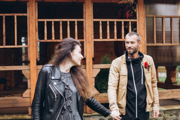 Tender romantic cheerful happy couple walking outdoors hugging and kissing each other outdoors in park. Relationships, love, hipster couple concept