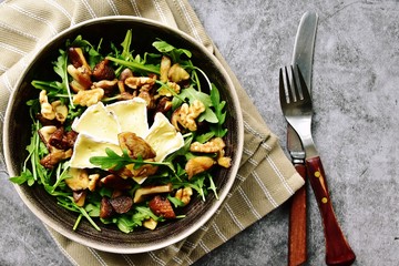 Mushrooms, dried figs and walnut salad with brie cheese. Top view salad isolated