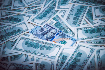 Background from dollars. Notes of one hundred American dollars are scattered across the background.