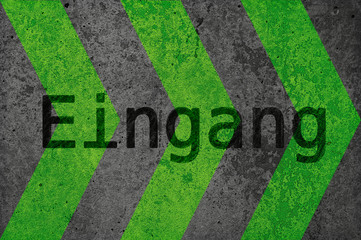 Eine Wand aus Beton hat gruene aufgebrachte Pfeile. Deutscher Text: Eingang.  Ideal als Hintergrund...