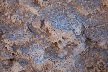 Vintage mud wall in the desert made with beach rocks and coral stones. Texture of stone old wall, old dry coral of brown color. Natural background.