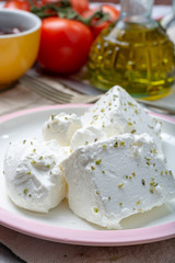 Fresh young soft white Feta cheese on plate seasoned with dried oregano herb