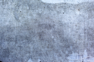 The texture of torn white fabric with a large cage or burlap, curtain, background