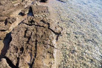Stone coastline. Rocks and water. Natural background. Stone texture of the edge of the water