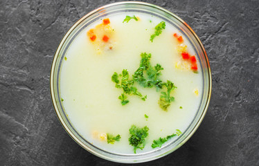 chicken cream soup in the glass bowl on Dark grey black slate background