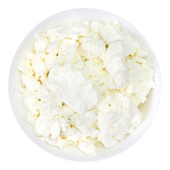 An overhead photo of fresh natural cottage cheese in a white ceramic bowl isolated on white. Organic eco healthy meal, dairy product. Top view.