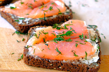 sandwich with salmon sprinkled with greens on rye bread