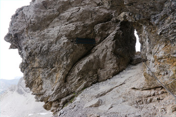 Fototapeta na wymiar Hiking throug a hole, gap in a rock, in the european alps