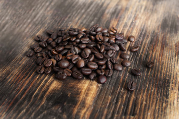 Brown arabica coffee beans on a wooden board.