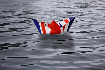 United Kingdom sailing alone in the sea like a paper ship made as the English flag Union Jack -...